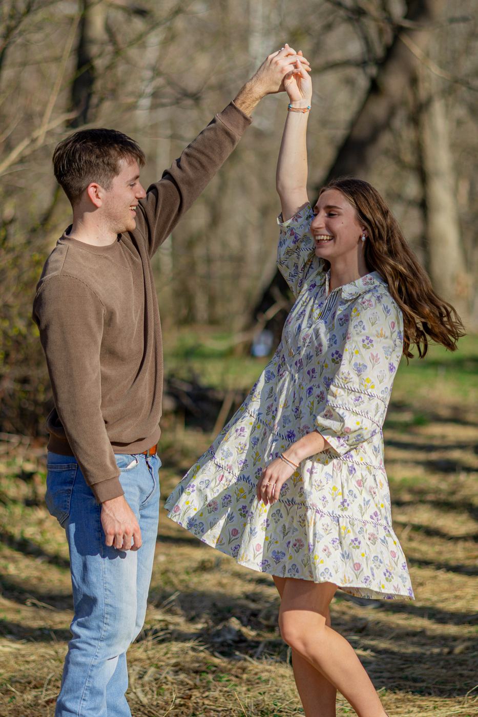 Couple dancing in a field after a proposal